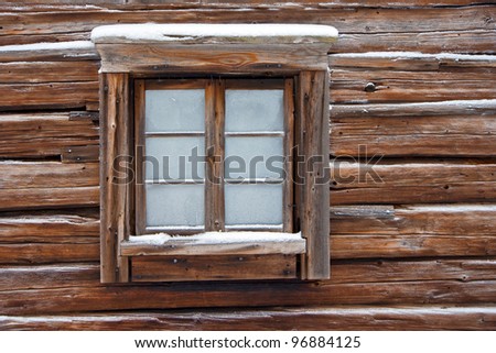 Frozen window of old log cabin