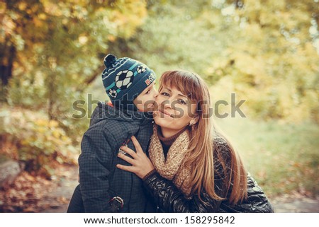 Picture of Son kiss his mother in the autumn forest