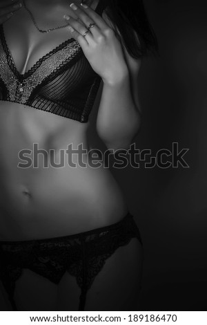Body part of the Beautiful and sexy woman wearing lingerie over black. Black and white colors