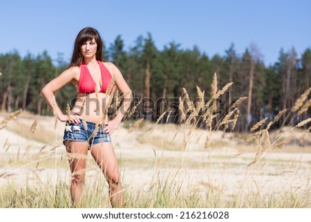 sexy girl posing in the tree roots at the sand. nature background