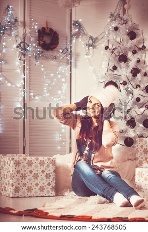 Beautiful girl near christmas tree on christmas light vintage background