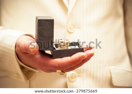 The groom is holding the wedding rings in his hand Wedding theme