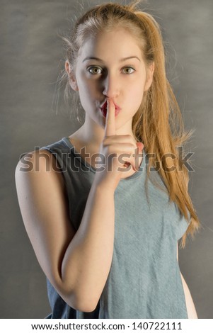 young beautiful woman with finger in its lips saying to him to be kept silent