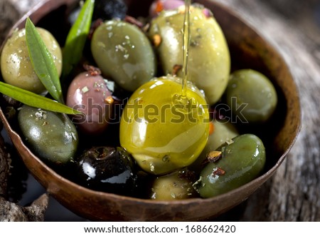 different olive fruits on wooden trunk of an olive tree