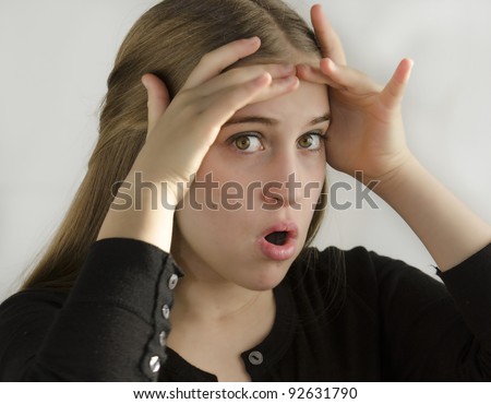 frightened girl with hands on head