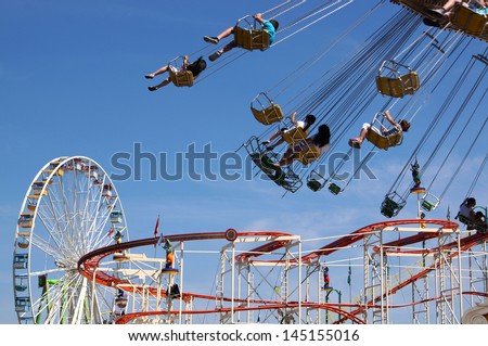 HANOVER, GERMANY - JULY 7 - Ferris wheel, roller coaster and chairoplane carousel at the annual Schuetzenfest fun fair on July 7th, 2013