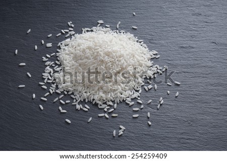 pile of white long-grained rice on black slate serving board