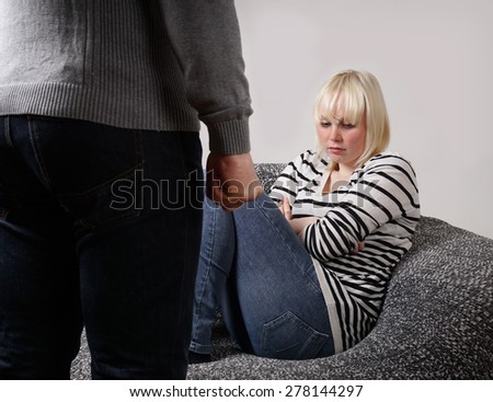 relationship difficulties man with clenched fist standing in front of defensive young woman