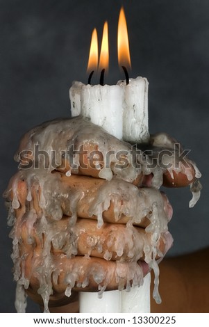 Three candles in hand with dripping wax