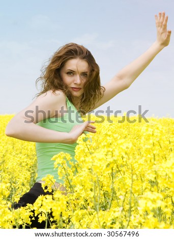 Portrait of a beautiful girl doing yoga in yellow flowers field