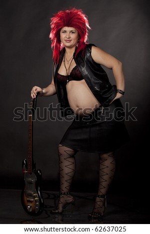 stock photo Pregnant sexy woman acting as rock star with red rumpled wig