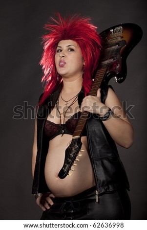 stock photo Pregnant sexy woman acting as rock star with red rumpled wig 