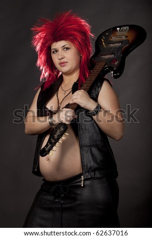 stock photo Pregnant sexy woman acting as rock star with red rumpled wig 