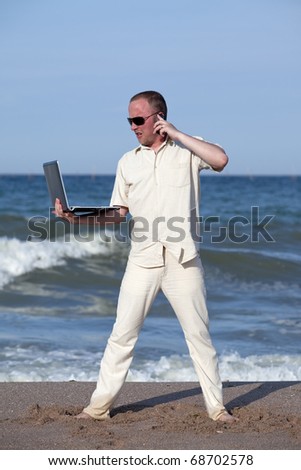 Frustrated sunburnt businessman at the beach with his laptop