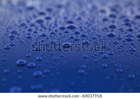 rain drops on blue car body, shallow focus