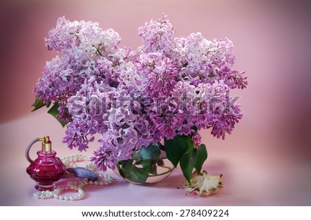 Still life with blooming branches of lilac, vintage perfume bottle, pearls and seashell