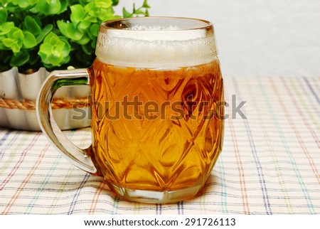 Mug of light beer on a table in the pub or cafe