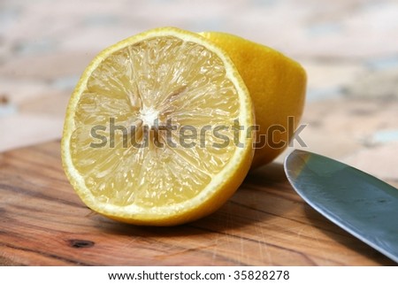 yellow lemon cut on a olive tree plank