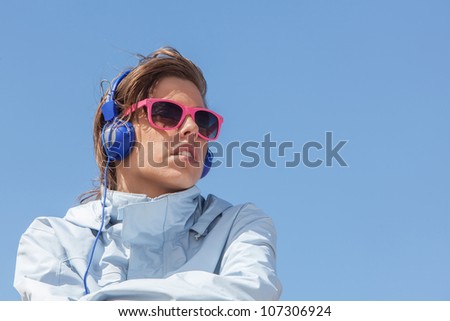 Girl listening to music with pink sun glasses