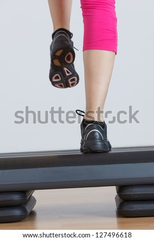 Close up of feet in step equipment at gym