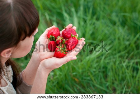 Fresh strawberries closeup. Woman holding strawberry in hands