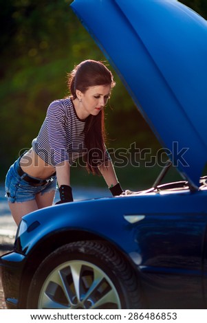 Sexy woman near her luxury car. Woman  standing near open car hood.