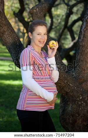 Young pregnant woman with yellow  apple. Natural bio food is good for pregnancy