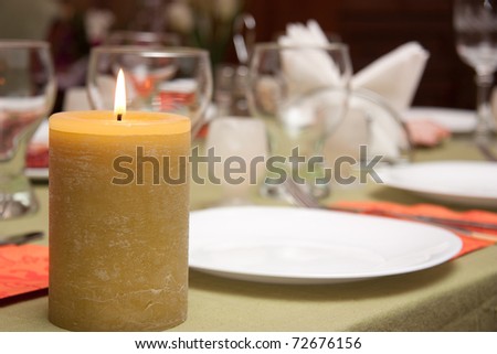 Candle in the decorated table, romantic dinner, restaurant