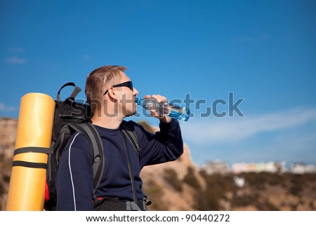 Tourist with backpack drinking some water