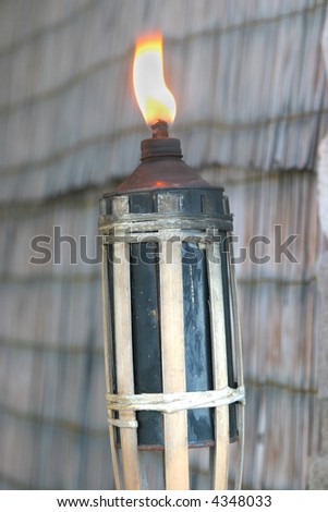 tiki torch lit on a rustic background