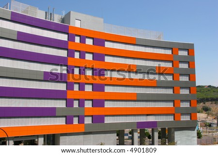 purple and orange office building against a bright blue sky