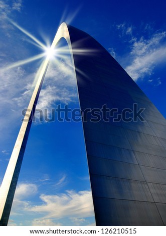 St. Louis Arch in Missouri with clouds and sky in background reflection of the sun