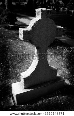 Gravestone cross in cemetery representing death marker grave stone