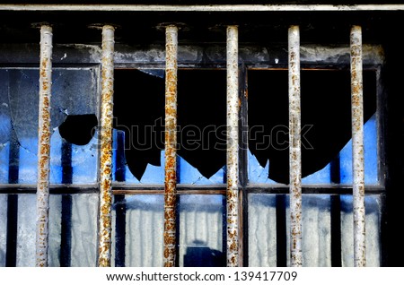 Security bars on broken window to prevent breaking into building