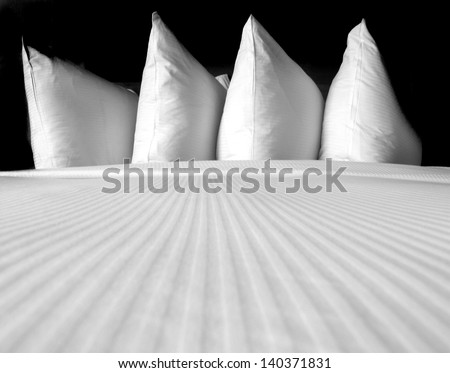 Group of several white pillows on a comfortable bed