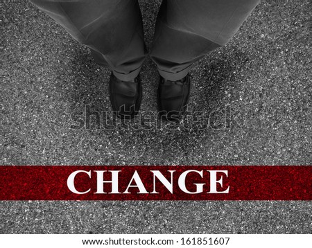 Businessman standing on asphalt starting line with motivation word of change