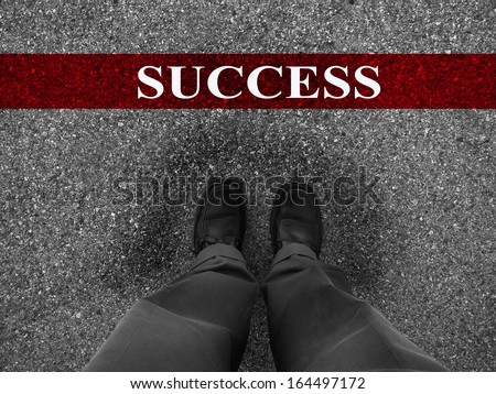 Businessman standing on asphalt starting line with motivation word of Success