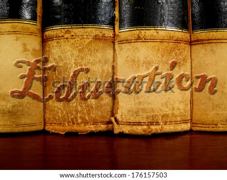 Row of old leather books on a shelf with word education cover