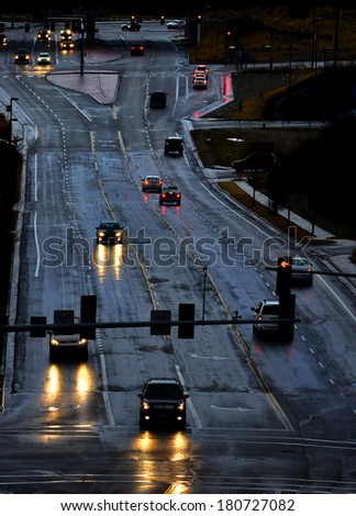 Cars with headlights shinning on stormy wet road driving in rain