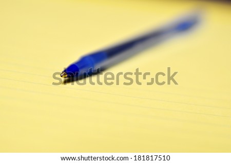 Closeup of blue ball point pen for business or education on legal pad
