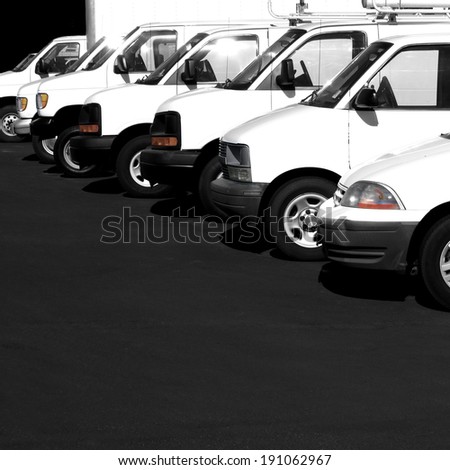 Several cars vans and trucks parked in parking lot for sale