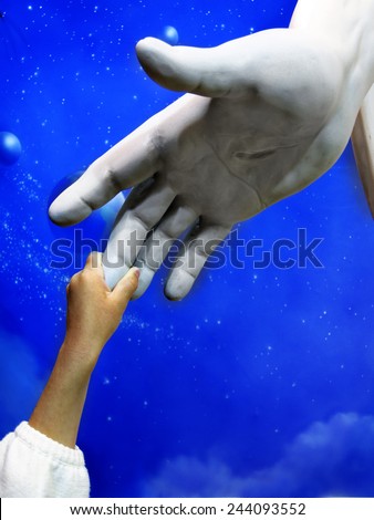 Little child holding hand of Jesus Statue showing faith spirit religion belief