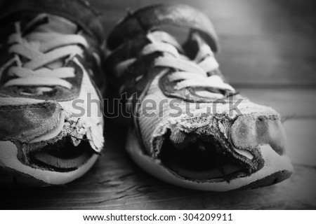 Old shoes with holes worn down shabby for homeless clothing
