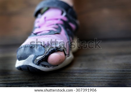 Old shoes with holes worn down shabby for homeless clothing toes sticking out