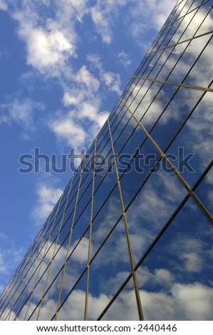 Office building details reflecting, blue sky and clouds in windows