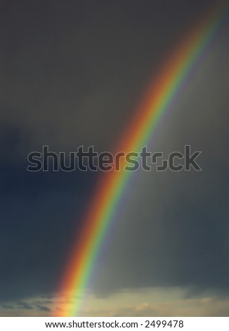 Colorful rainbow with dark storm clouds in background
