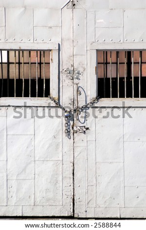 Old warehouse doors with chain and lock and wall