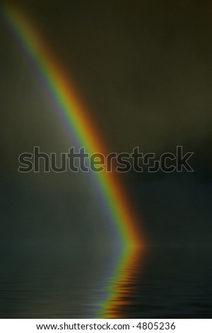 Colorful bright rainbow set against stormy sky