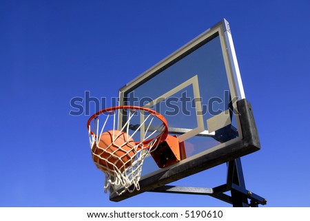 Action shot of basketball going through basketball hoop and net
