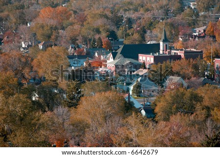 View of homes buildings and church in a town in the fall